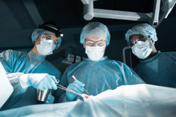 equipe médica realziando manobras abdominais em paciente