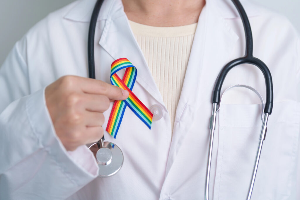 Médico_segurando_bandeira_Saúde_LGBTQIAP+